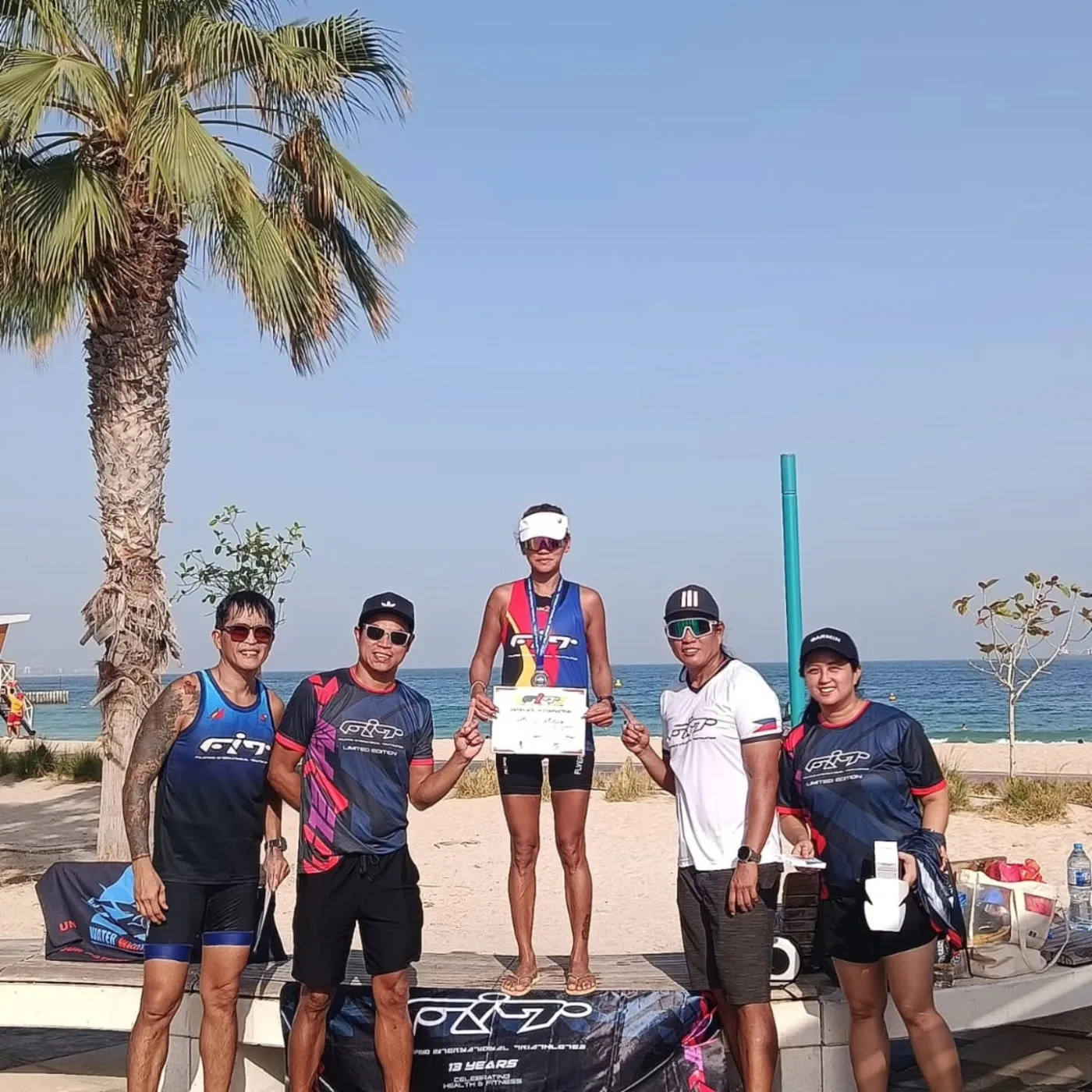 A FiT athlete celebrating on a podium with fellow community members